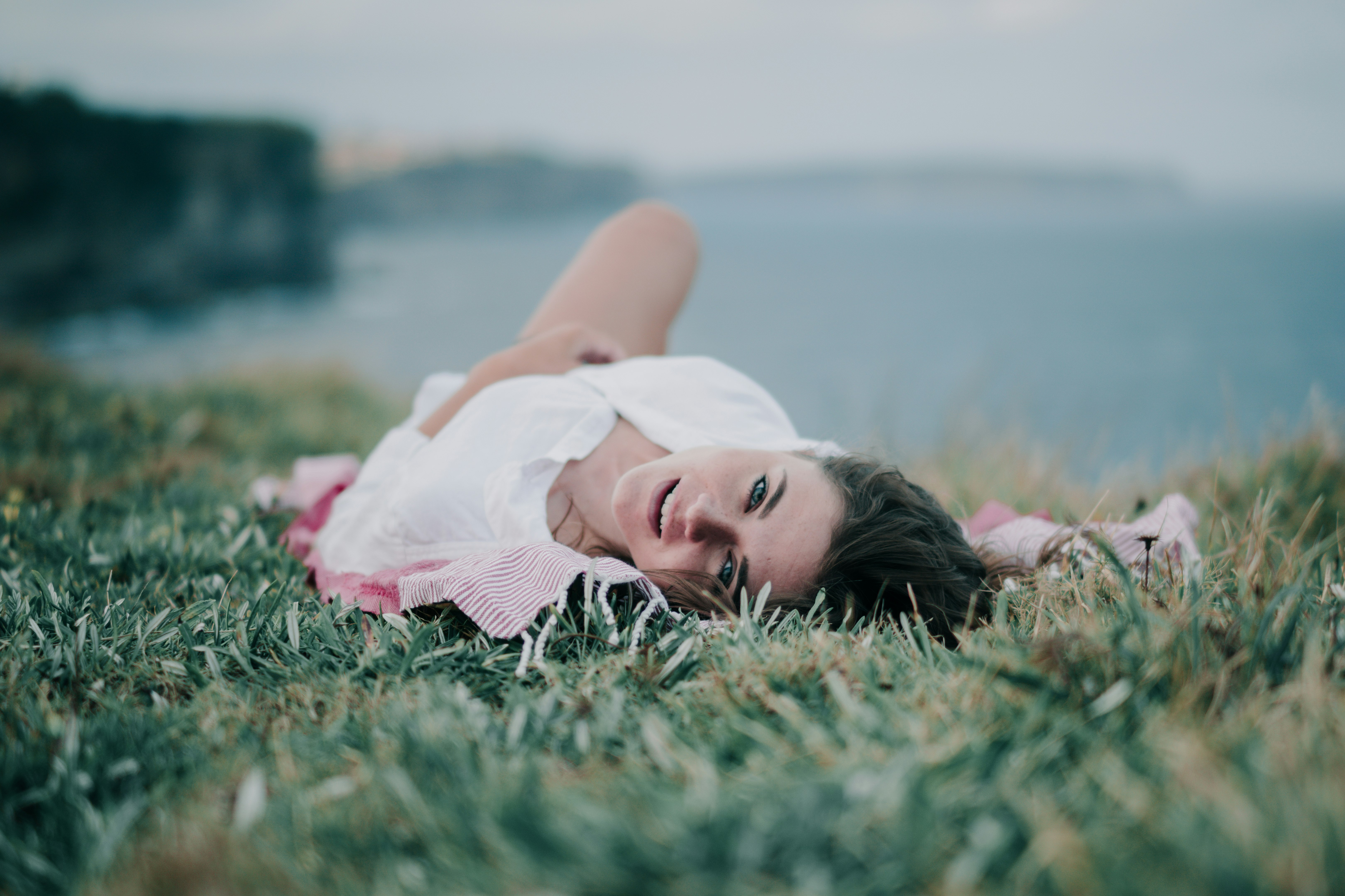 woman lying on green grass